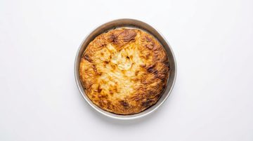 Frisch gebackener Börek in einer runden Blechform, von oben fotografiert